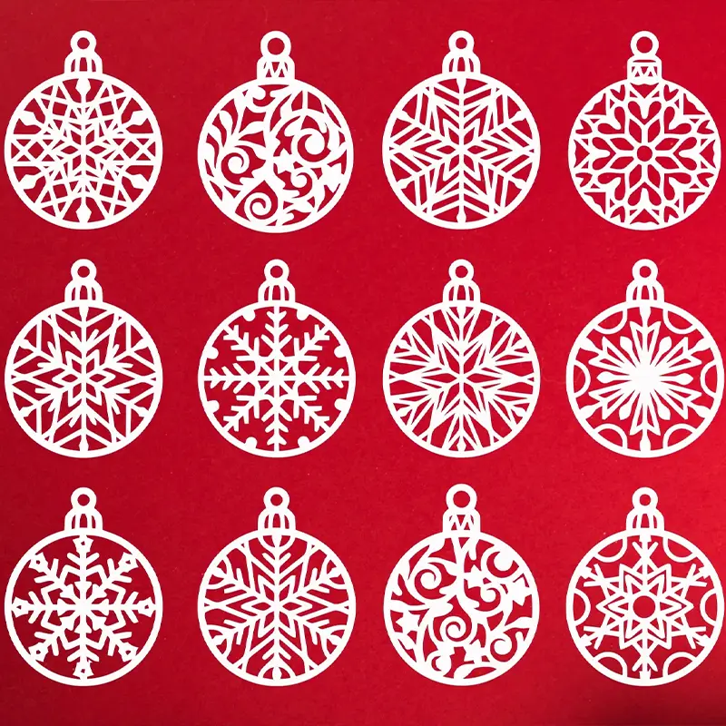 Twelve white 3D printed snowflake ornaments with intricate geometric patterns arranged in grid formation