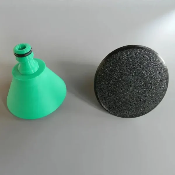 Close-up of custom 3D printed garden spray nozzle showing detailed design and water spray pattern