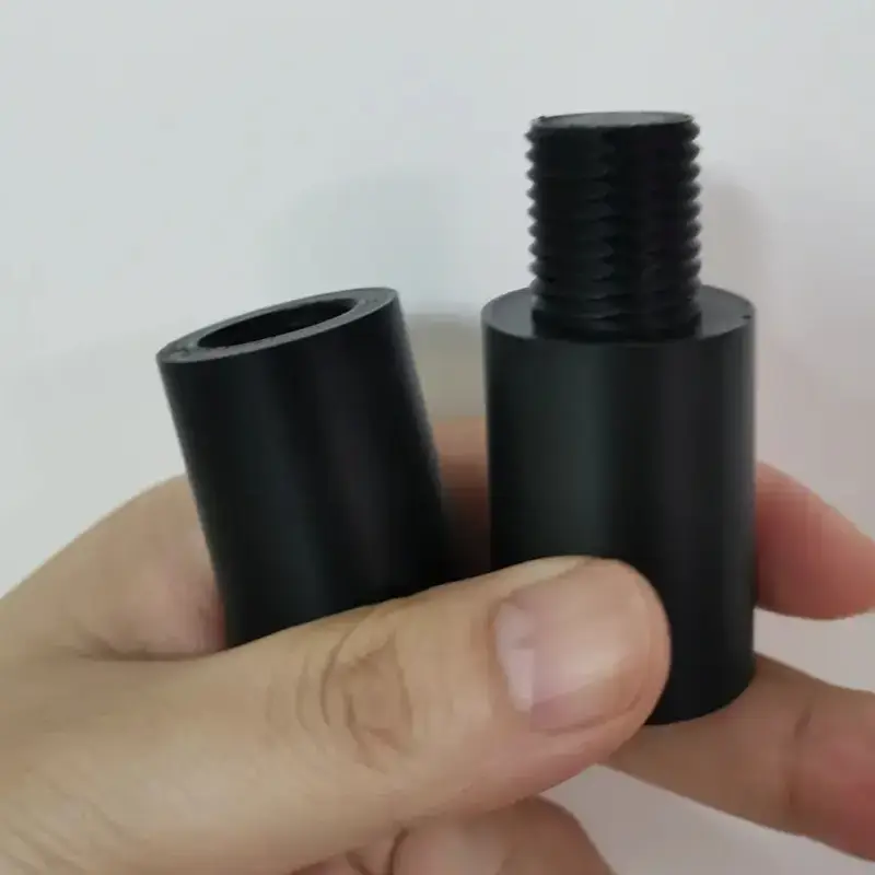 Black 3D printed threaded fastener components including screw pillars and nut pillars held in hands