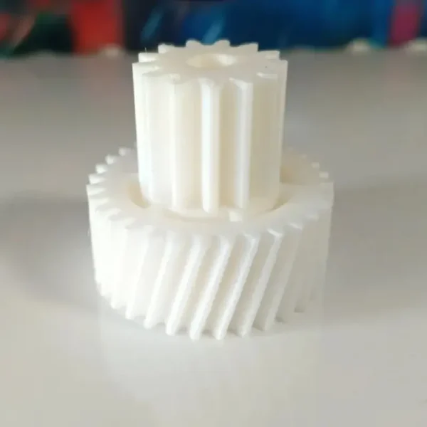 White 3D printed dual-layer gear system showing intricate two-layer design on neutral background