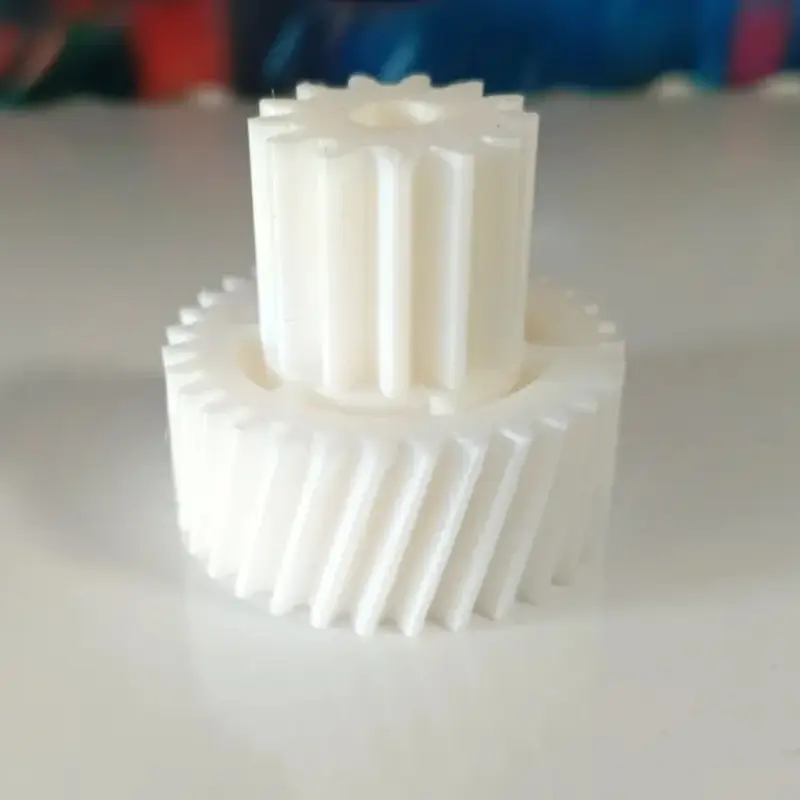 White 3D printed dual-layer gear system showing intricate two-layer design on neutral background