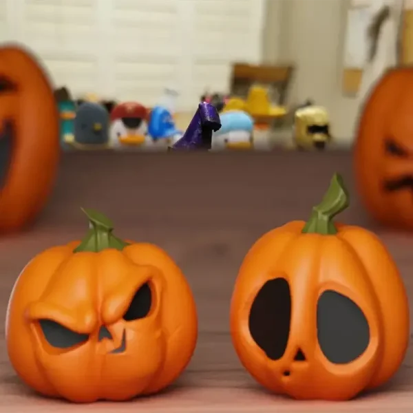 Two custom-carved 3D printed pumpkin ornaments with detailed faces on a wooden surface, showcasing Halloween decor for B2B clients