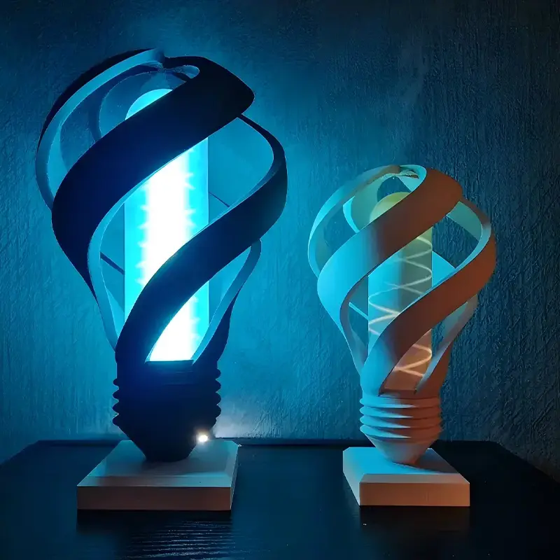 A custom 3D printed lamp cover with intricate blue swirl designs, emitting a soft blue light in a dark setting