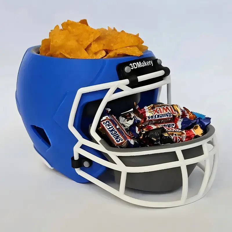 Blue 3D printed helmet snack bowl with Smurfs design, filled with chips and candies in separate compartments