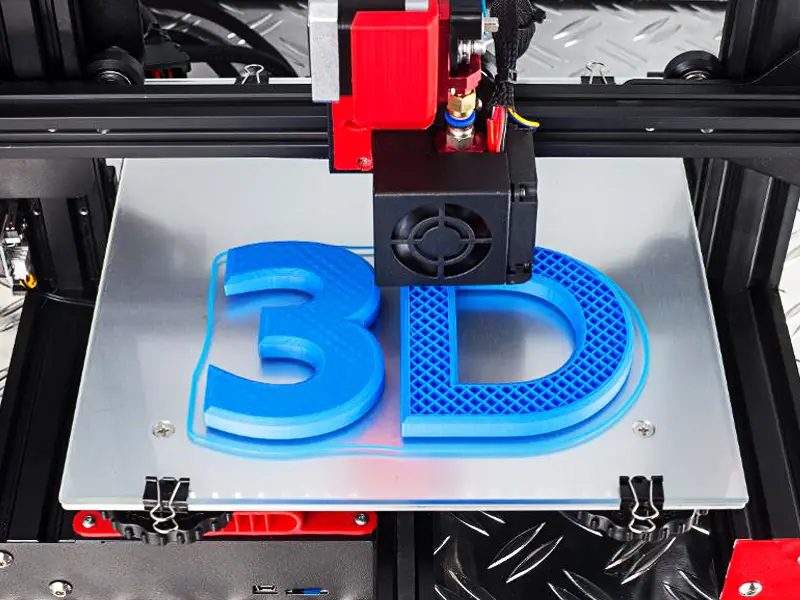 Industrial-grade FDM 3D printer actively creating blue '3D' lettering with visible layer lines, showcasing mass production capabilities for bulk orders in a professional workshop environment.