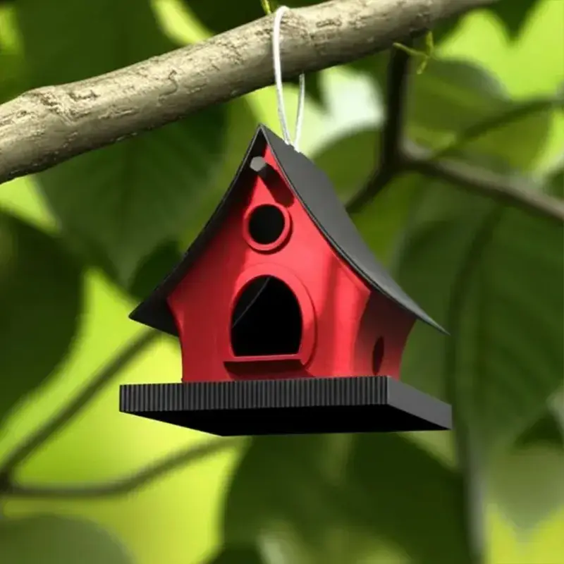 Charming 3D printed red birdhouse hanging from tree branch against green foliage, showcasing traditional design and easy-clean features