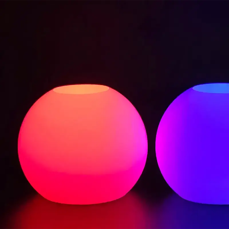 Two color-shifting 3D printed illuminated orbs in red and purple, glowing against a dark background, showcasing dynamic light effects