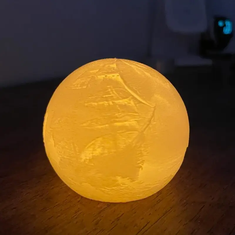 Yellow glow-emitting 3D printed orb with smooth texture casting warm light on wooden table in ambient setting