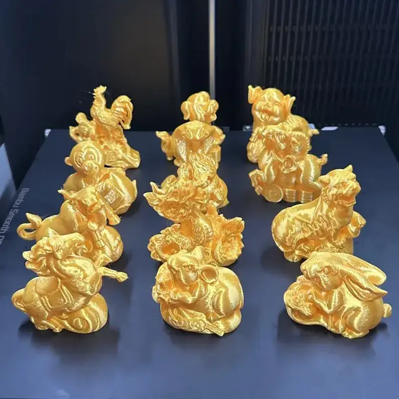 Set of twelve golden zodiac animal sculptures arranged elegantly on a dark surface, showcasing detailed 3D printing for B2B clients