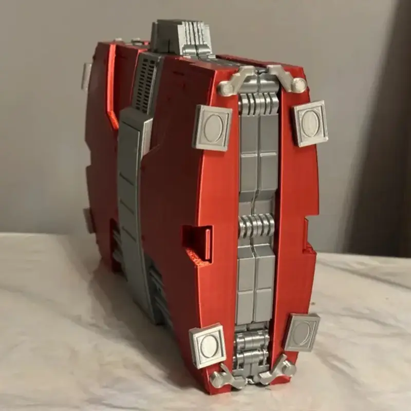 Red and gold 3D printed armor-inspired business case showing intricate panel details on neutral background