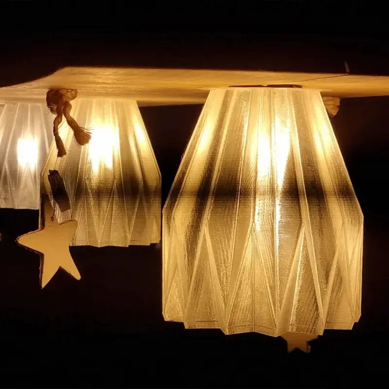 Bespoke 3D printed light bulb covers emitting a soft warm glow, hanging from a wooden beam in a commercial setting