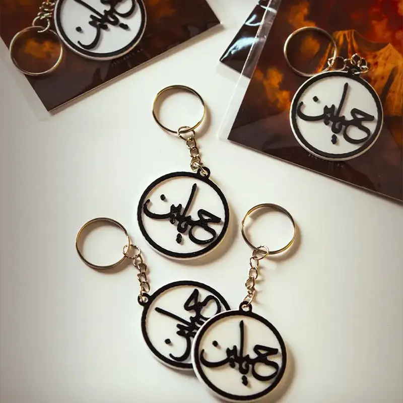 Set of three commemorative Arabic medallions featuring "عَبِيم" script in circular pattern on dark background