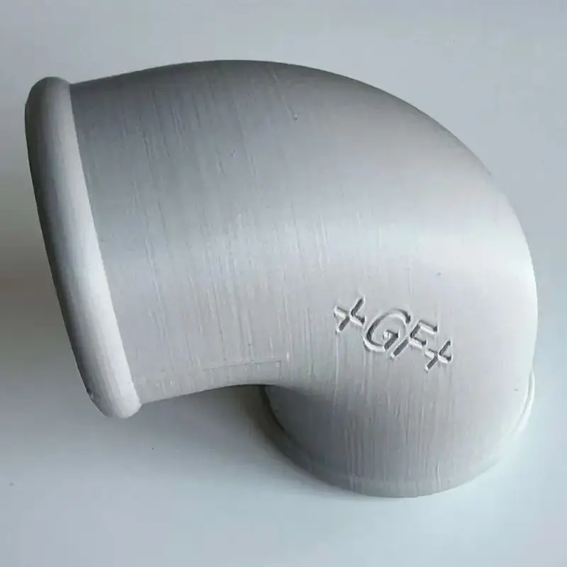 White 3D printed precision angled pipe connector with +GF+ certification marking on plain background