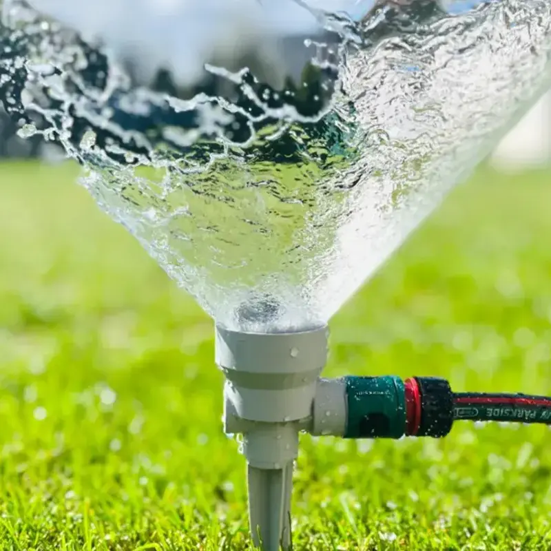 Close-up of 3D printed precision irrigation nozzle spraying water efficiently with visible droplets