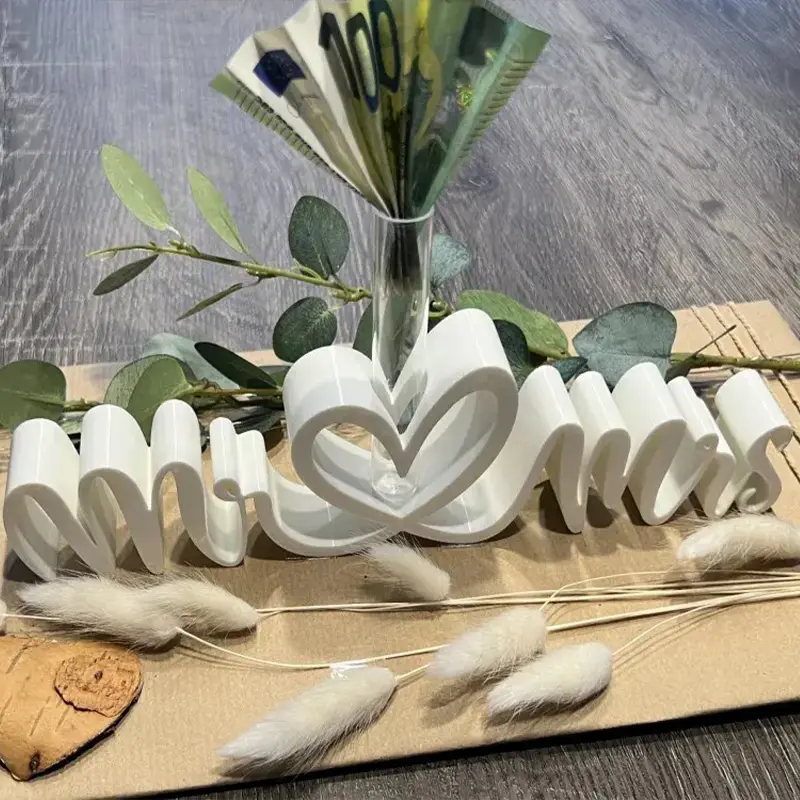 White 3D printed Mr & Mrs heart-shaped vase holding 100 Euro notes with eucalyptus leaves and pampas grass decoration