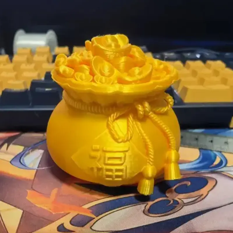 3D printed gold ingot and blessing bag ornament with "福" character, shown on a keyboard with detailed golden finish for B2B clients