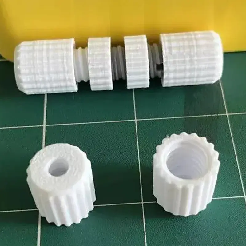 Set of white 3D printed advanced PTFE connection system parts on green cutting mat