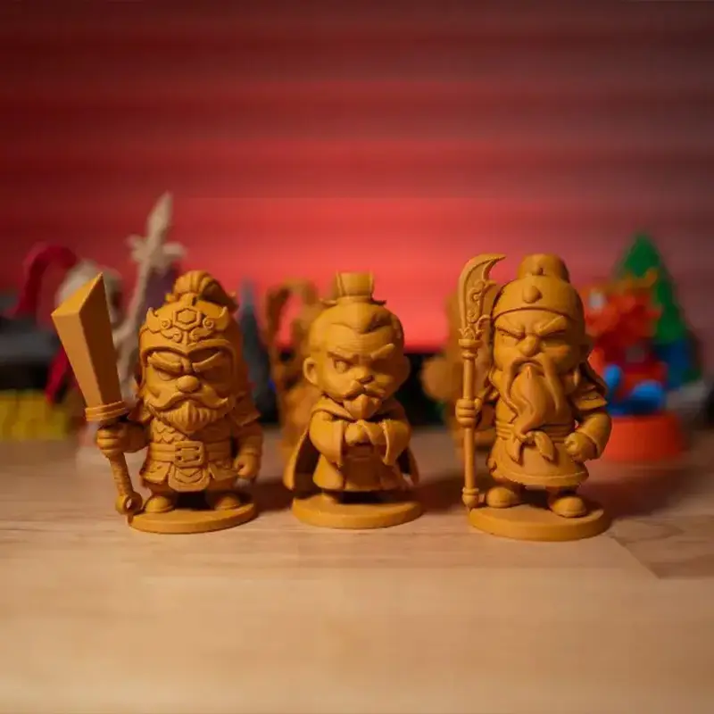 Set of three chibi Three Kingdoms figurines with detailed costumes and weapons, arranged on wooden surface for B2B clients