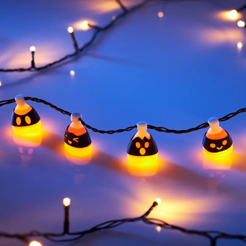 Set of four candy-inspired LED string lights with playful expressions and warm yellow glow against soft blue background
