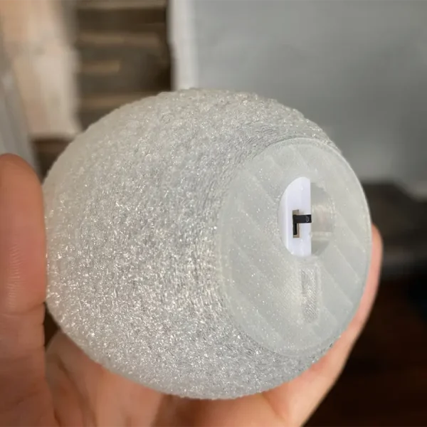 Professionally held iridescent 3D printed light sphere demonstrating customizable design options for B2B clients