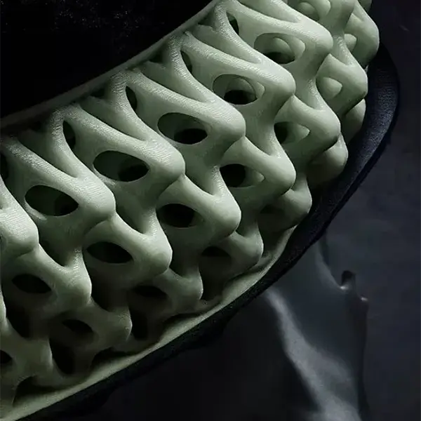 A modern manufacturing facility showing an industrial FDM printer actively producing a complex jig while an engineer uses a tablet to monitor the process, illustrating the integrated workflow.