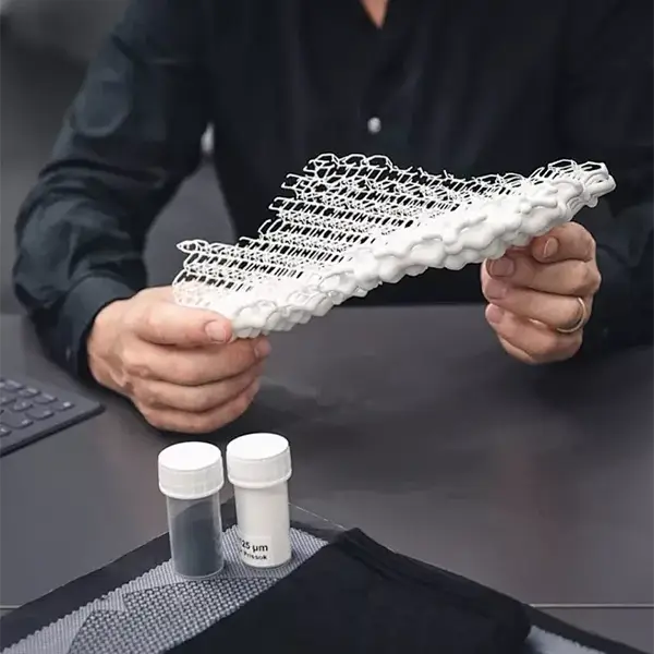Side-by-side comparison showing an FDM-printed bracket supporting heavy weights next to a traditionally manufactured metal bracket, demonstrating the strength of modern FDM printing.